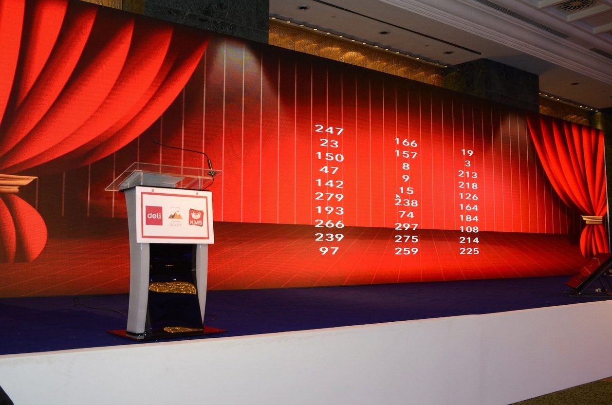 Red-curtain stage with branded podium and LED display built by Top-Tech